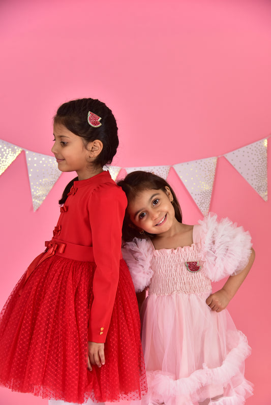Two girls in festive dresses on pink background, one wearing a handmade watermelon hair clip by Little Pink Llama