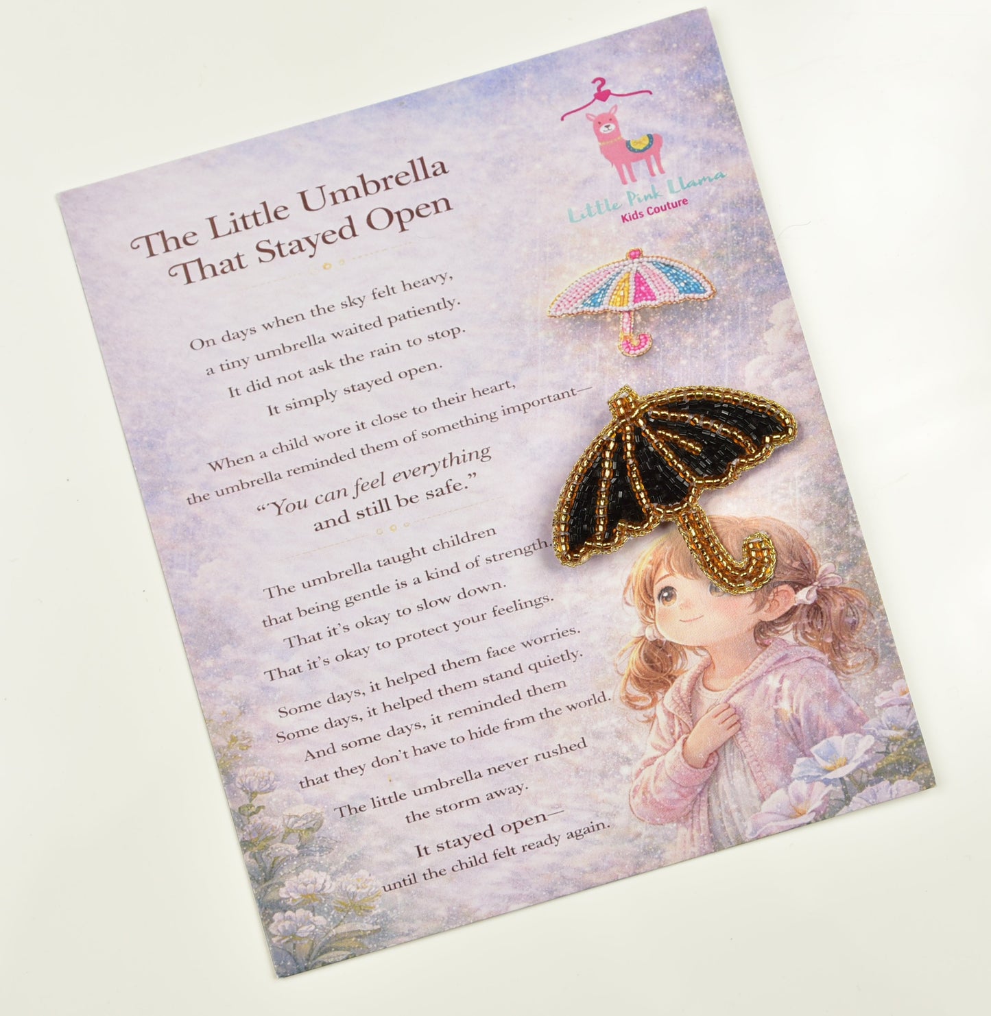 Black beaded umbrella hair clip on Little Pink Llama branded story card – The Little Umbrella That Stayed Open