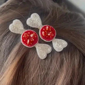 Two white beaded candy hair clips with red jeweled centers worn in dark hair - handcrafted kids accessory