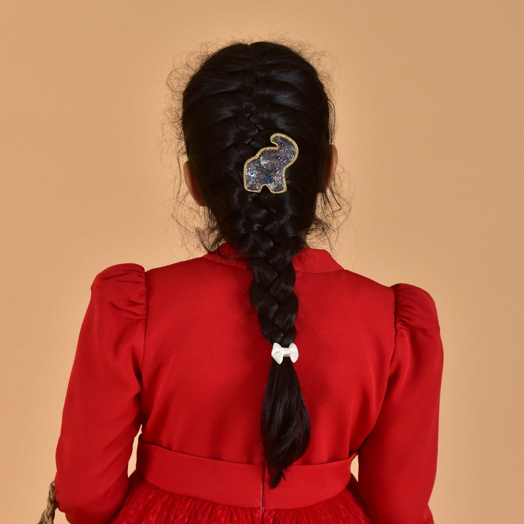 Back view of girl in red dress with braided hair featuring blue beaded elephant hair clip - lifestyle accessory photo