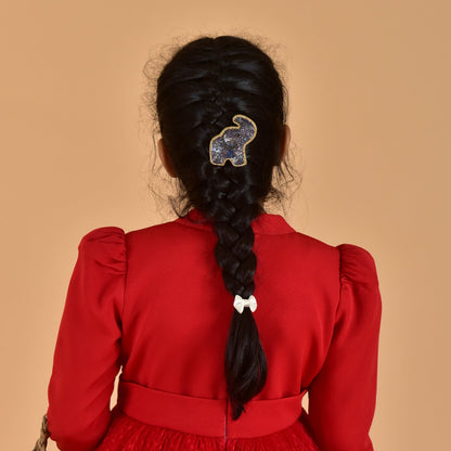 Back view of girl in red dress with braided hair featuring blue beaded elephant hair clip - lifestyle accessory photo