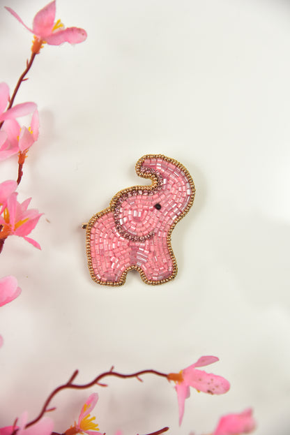 Pink handcrafted beaded elephant brooch with gold border against floral background—kids jewelry by Little Pink Llama