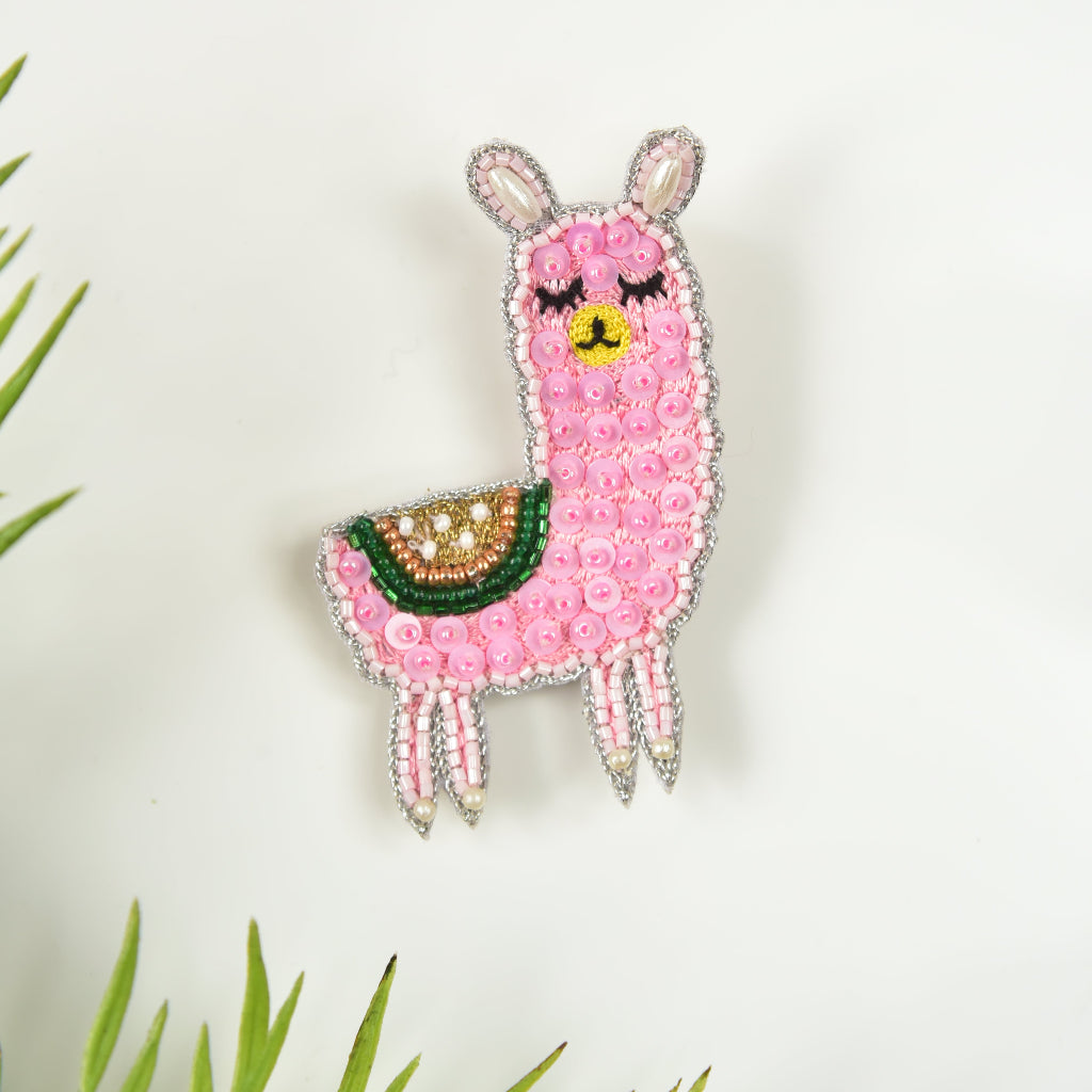 Handmade pink llama hair clip with beaded rhinestone detail and green saddle – Little Pink Llama kids hair accessory on white background