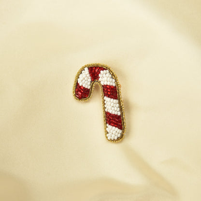 Handmade beaded candy cane hair clip with red and white beads on cream fabric – festive holiday hair pin