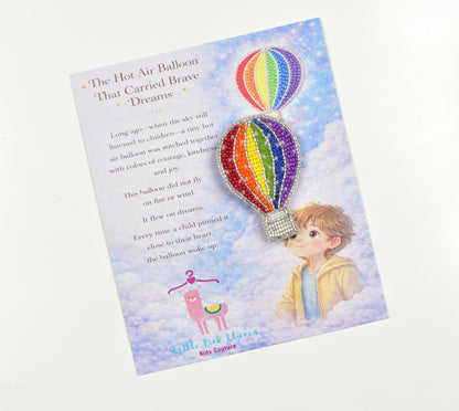 Little Pink Llama hot air balloon brooch on gift card titled The Hot Air Balloon That Carried Brave Dreams with child illustration