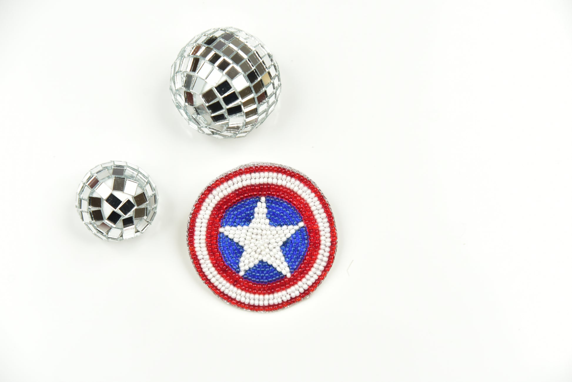 Captain America beaded shield brooch displayed alongside disco ball brooches on white background