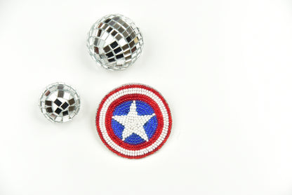 Captain America beaded shield brooch displayed alongside disco ball brooches on white background