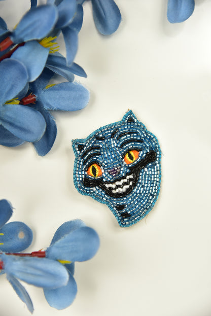 Blue beaded Derpy Tiger hair clip flat lay with blue flowers on white background - handcrafted kids gift